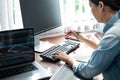 Asian woman programmer holding pen and looking on keyboard to typing code data about new project on laptop