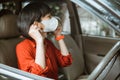 Woman in protective mask driving a car on road. Safe traveling. Royalty Free Stock Photo