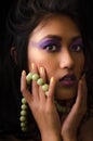 Asian woman with purple make-up and green necklace