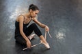 Asian woman puts on pointe shoes by tying ribbons on her ankle. Royalty Free Stock Photo