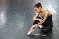 Asian woman puts on pointe shoes by tying ribbons on her ankle. Royalty Free Stock Photo