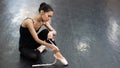 Asian woman puts on pointe shoes by tying ribbons on her ankle. Royalty Free Stock Photo