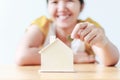 Asian woman putting money coin in to house piggy bank metaphor s Royalty Free Stock Photo