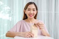 Asian woman putting money coin in to house piggy bank metaphor saving money financial for buy the home Royalty Free Stock Photo