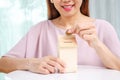 Asian woman putting money coin in to house piggy bank metaphor saving money financial for buy the home Royalty Free Stock Photo