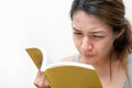 Asian woman reading book, has bad vision sight problems, selective focus, myopia and eyesight problem concept Royalty Free Stock Photo