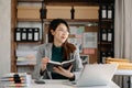 Asian woman reading book while sitting at  in cafe or home office Royalty Free Stock Photo