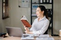 Asian woman reading book while sitting at in cafe or home office Royalty Free Stock Photo