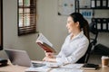 Asian woman reading book while sitting at in cafe or home office Royalty Free Stock Photo