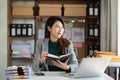 Asian woman reading book while sitting at  in cafe or office Royalty Free Stock Photo