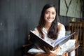 Asian women reading and smiling and happy Relaxing in a coffee shop after working in a successful office Royalty Free Stock Photo