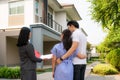 Asian woman Real estate broker agent showing a house detail in her file to the young Asian couple lover looking and interest to Royalty Free Stock Photo