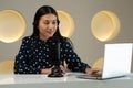 Asian woman recording a podcast on laptop computer with microphone while online live streaming Royalty Free Stock Photo