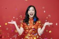 Asian woman with red cheongsam or qipao exciting and laughing for wishing the good luck and prosperity in Chinese New Year with