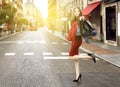 Asian woman in red clothes and sunglasses carrying black shopping bags in the city