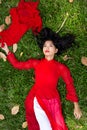 Asian Woman in Red on Grassland