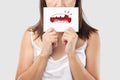 Asian woman in the red shirt holding a brown paper with the broken tooth cartoon picture of his mouth against the gray background Royalty Free Stock Photo