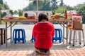 Asian woman red shirt sitting and praying to ancestor with meal,dessert and beverage on table in new year chinese