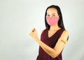 Asian woman in red  sleeveless t-shirt and cloth face mask  wearing Plaster Bandage On her Arm After Coronavirus vaccine injection Royalty Free Stock Photo