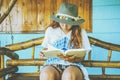 Asian women relax in the holiday. sit read a book on a wooden swing. Home Front porch. In Thailand Royalty Free Stock Photo