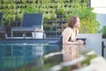 Asian woman relax in swimming pool on roof top with sunset view with high rise skyscape urban downtown, Happiness lifestyle and Royalty Free Stock Photo