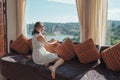 Asian woman relaxing and enjoying the tropical forest view on sofa at panorama room in bright day Royalty Free Stock Photo