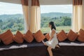 Asian woman relaxing and enjoying the tropical forest view on sofa at panorama room in bright day Royalty Free Stock Photo