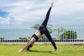 Asian woman relaxing in yoga Seperate leg stretching Pose exercises muscle for warm up on the beach Royalty Free Stock Photo