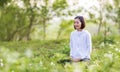 Asian woman is relaxingly practicing meditation yoga in forest full of daisy flower in summer to attain happiness from inner peace
