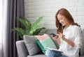 Asian women are relaxingly working at home. She using phone to contact people