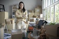 Asian woman retail seller, entrepreneur, online store drop-shipping small business owner looking at camera standing in delivery