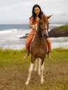 Asian woman riding horse near the ocean. Outdoor activities. Traveling concept. Vertical layout. Bali Royalty Free Stock Photo