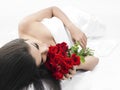 Asian woman with roses in bed Royalty Free Stock Photo