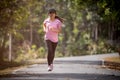 Asian woman runner running in the morning tropical forest trail. Concept nature and sport lifestyle Royalty Free Stock Photo