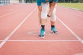 Asian woman runner suffering from pain in leg be injured,Hands touching her knee after jogging and workout outdoor on track runni Royalty Free Stock Photo