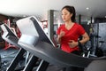 Asian women running sport shoes at the gym while a young caucasian woman is having jogging on the treadmill Royalty Free Stock Photo