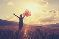 Asian woman running on sunset grassland with colored balloons Royalty Free Stock Photo