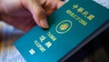 Asian woman`s hand hold her Taiwan green passport. Travel foreign countries