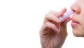 Asian Woman`s hand hold nasal inhaler and inhale through nostril to relief nasal congestion for breathing more comfortable and hel