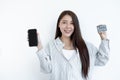 The Asian woman`s hand is holding a credit card and using a smartphone for online shopping and internet payment in a happy way Royalty Free Stock Photo