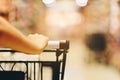 Asian woman`s hand with supermarket, trolley and many objects that are blurred background Royalty Free Stock Photo