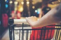 Asian woman`s hand with supermarket, trolley and many objects that are blurred background Royalty Free Stock Photo