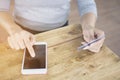 Asian woman`s hands holding a credit card and using smart phone for online shopping Royalty Free Stock Photo