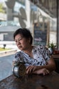 Asian woman waiting in coffee shop cafe with clock Royalty Free Stock Photo