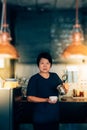 Asian woman barista pouring latte in coffee shop Royalty Free Stock Photo