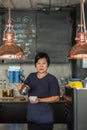 Asian woman barista pouring latte in coffee shop Royalty Free Stock Photo