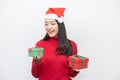 Asian Woman With Santa Claus Hat Holding Two Gifts on Both of Her Hands Do Not Know Which one To Choose Royalty Free Stock Photo