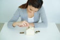 Asia woman saving money with shaped house box Royalty Free Stock Photo