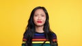 Asian woman say yes and then say no on yellow background