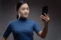 Asian woman scans face by smart phone using facial recognition system Royalty Free Stock Photo